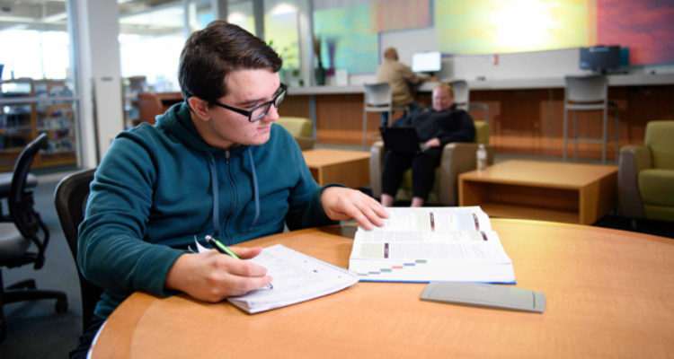 Student studying in common area by himself