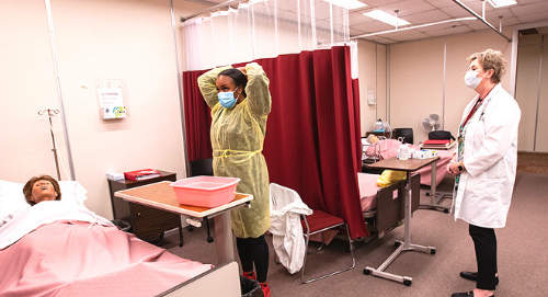 nursing student and instructor in lab classroom