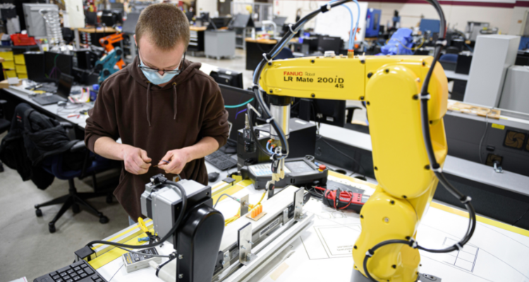 student working with robotic arm in lab