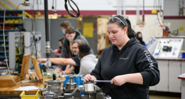 students testing industrial machine with instructor supervising