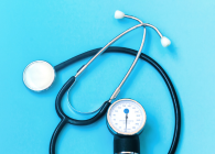 Stethoscope and blood pressure monitor on a light blue background.