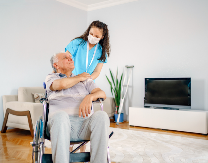 female healthcare worker with elderly man in wheelchair