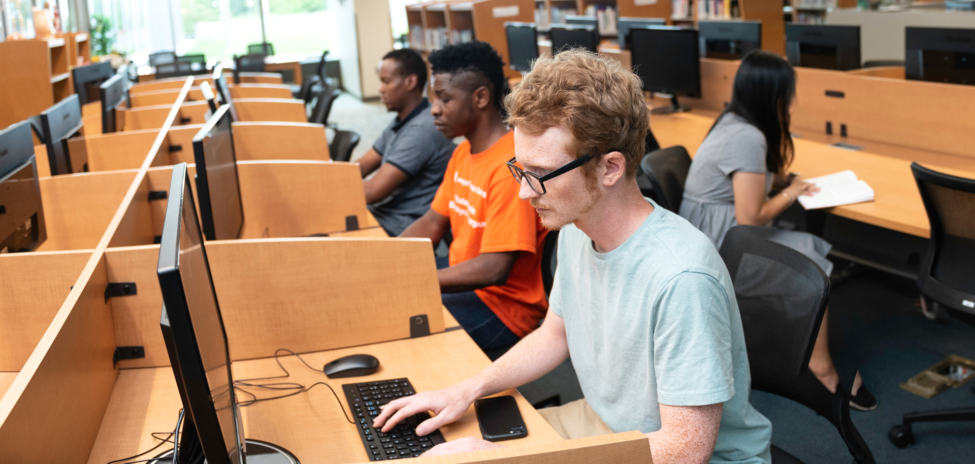 male student sitting at computer work station