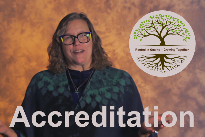 Speaker presenting about accreditation with the word 'Accreditation' displayed on screen and a tree logo reading 'Rooted in Quality – Growing Together